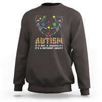 Dark brown autism awareness crewneck sweatshirt with skeleton puzzle graphic and rainbow text