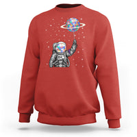 Red astronaut graphic sweatshirt with colorful planet balloon and starry background