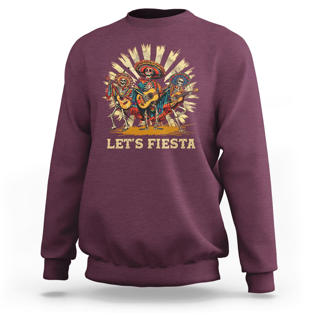 Maroon sweatshirt with “Let’s Fiesta” graphic of dancing skeletons