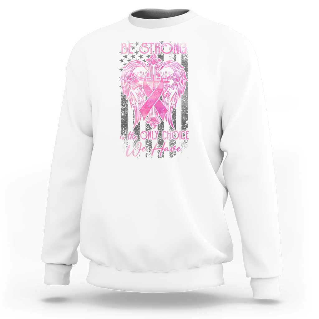 White crewneck sweatshirt with pink ribbon graphic and 'Be Strong' slogan