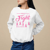 White crewneck sweatshirt with pink "Pray Fight Believe" text and ribbon graphic.
