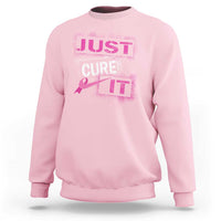 Light pink breast cancer awareness sweatshirt with “Just Cure It” chest graphic