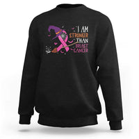 Black crewneck sweatshirt with pink ribbon witch graphic and “I AM STRONGER” text