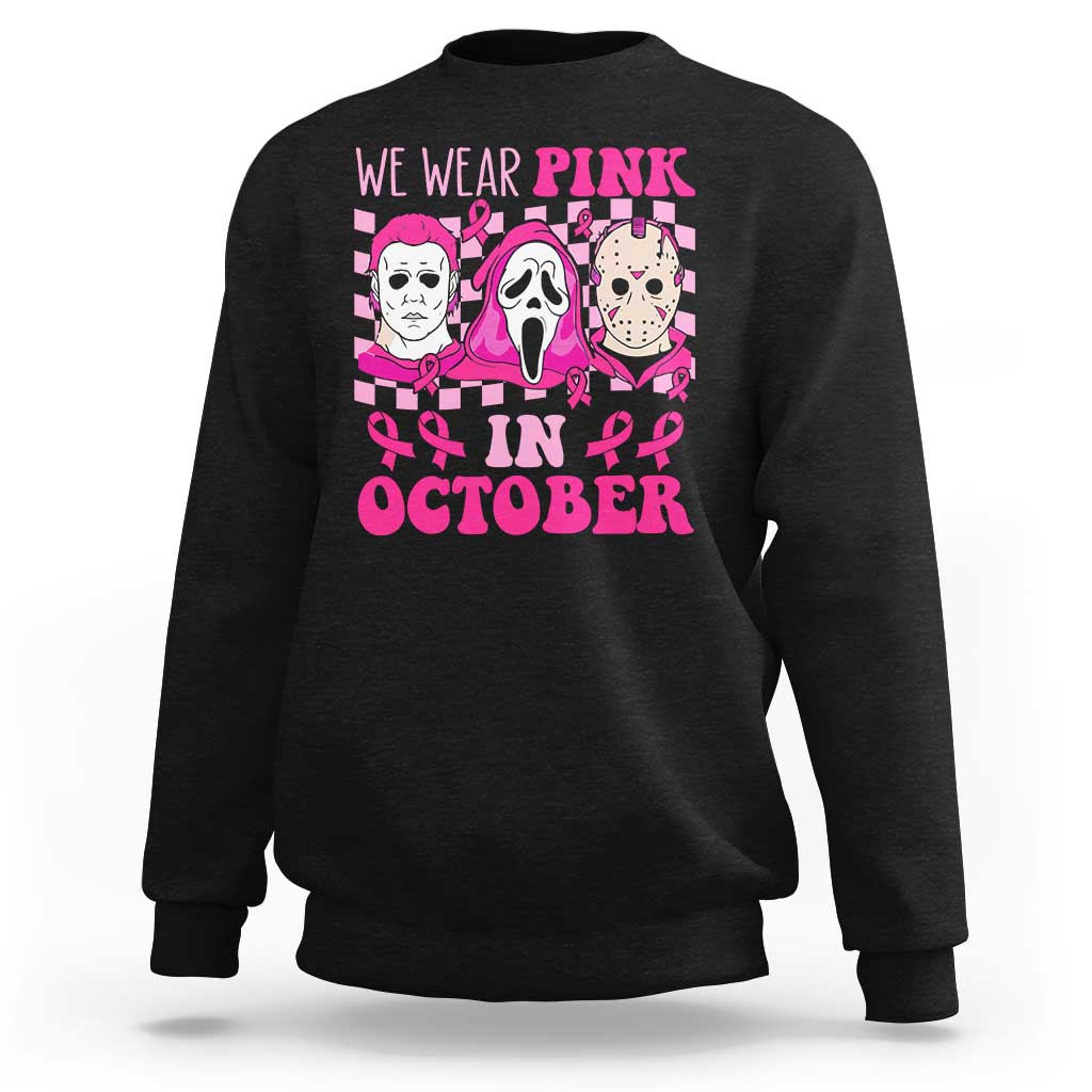 Black crewneck sweatshirt with long sleeves and pink “We Wear Pink in October” graphic