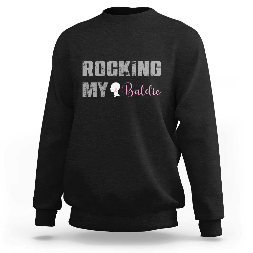 Black crewneck sweatshirt with “ROCKING MY Baldie” graphic and ribbon icon