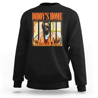 Black crewneck sweatshirt with “DIDDY’S HOME” graphic and portrait print on chest.