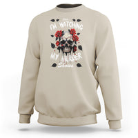 Sand color crewneck sweatshirt with skull and roses graphic on the chest, long sleeves.