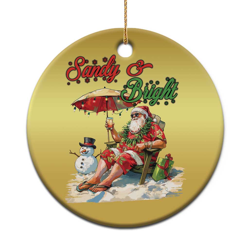 Gold round Christmas ornament with Santa at the beach and “Sandy & Bright” text