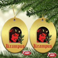 Gold oval hanging ornament set with red-and-black horned female face and holly, two sides