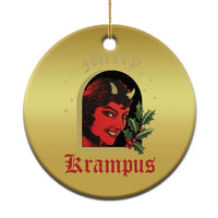 Gold round hanging Christmas ornament with red-and-black horned female face and holly