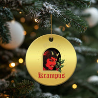 Gold round hanging Christmas ornament featuring a red-and-black horned female face with holly
