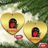 Gold heart-shaped hanging Christmas ornament with red-and-black horned female face and holly