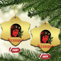 Gold heart-shaped hanging ornament with red-and-black horned female face and holly, two sides