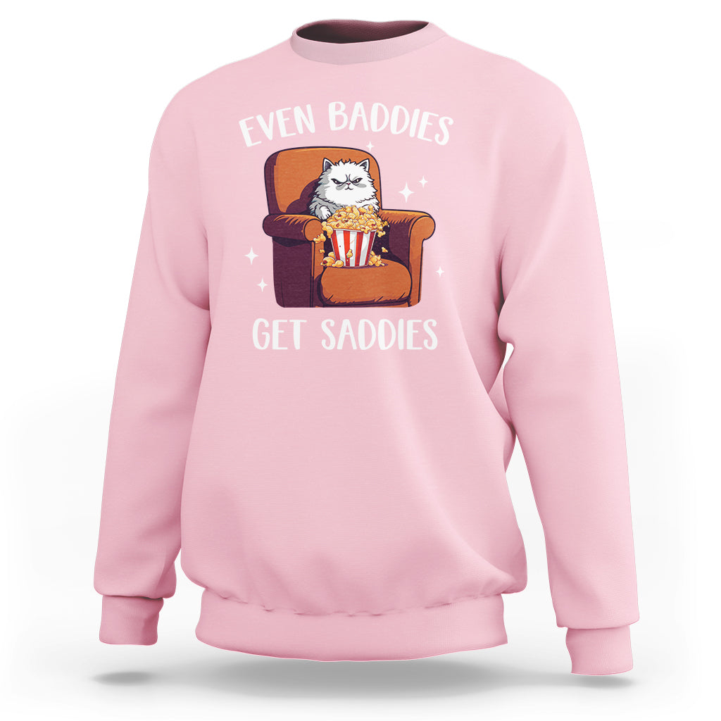 Light pink sweatshirt with cartoon cat graphic and 'Even Baddies'/'Get Saddies' text