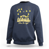Navy Christmas light graphic sweatshirt with gold nativity scene and “Follow The light” text