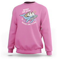 Pink sweatshirt with whale graphic and text “Protect Our Ocean, Protect Our Future”
