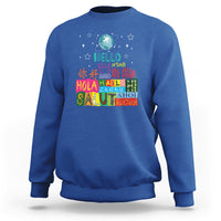 Royal blue crewneck sweatshirt with “Hello” graphic and multicolor globe print on front.