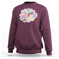 Maroon sweatshirt with multicolor circular “hello” greetings graphic on the chest