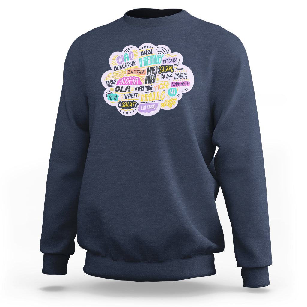 Dark blue sweatshirt with multicolor circular “hello” greetings graphic on the chest