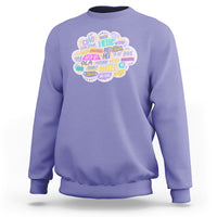 Light purple sweatshirt with multicolor circular “hello” greetings graphic on the chest