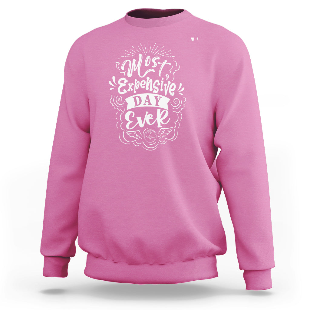 Azalea pink crewneck sweatshirt with white 'Most Expensive Day Ever' graphic on chest