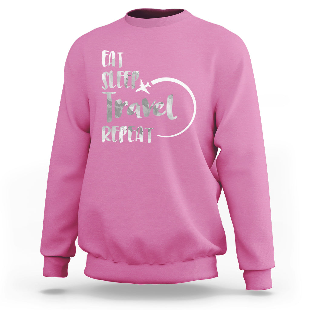 Pink crewneck sweatshirt with 'Eat Sleep Travel Repeat' graphic on back.