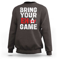 Dark chocolate sweatshirt with “Bring Your Eh Game” Canada flag and maple leaf graphic