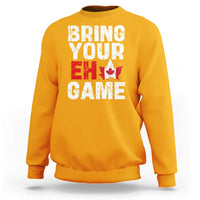 Gold sweatshirt with “Bring Your Eh Game” Canada flag and maple leaf graphic