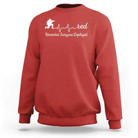 Red crewneck sweatshirt with white heartbeat graphic and soldier icon on chest