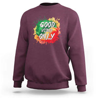 Maroon crewneck sweatshirt with colorful “Good Vibes Only” rasta graphic on front