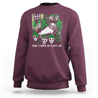 Maroon crewneck sweatshirt with green skull-and-plant graphic on front