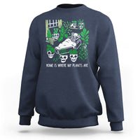 Navy crewneck sweatshirt with green skull-and-plant graphic on front