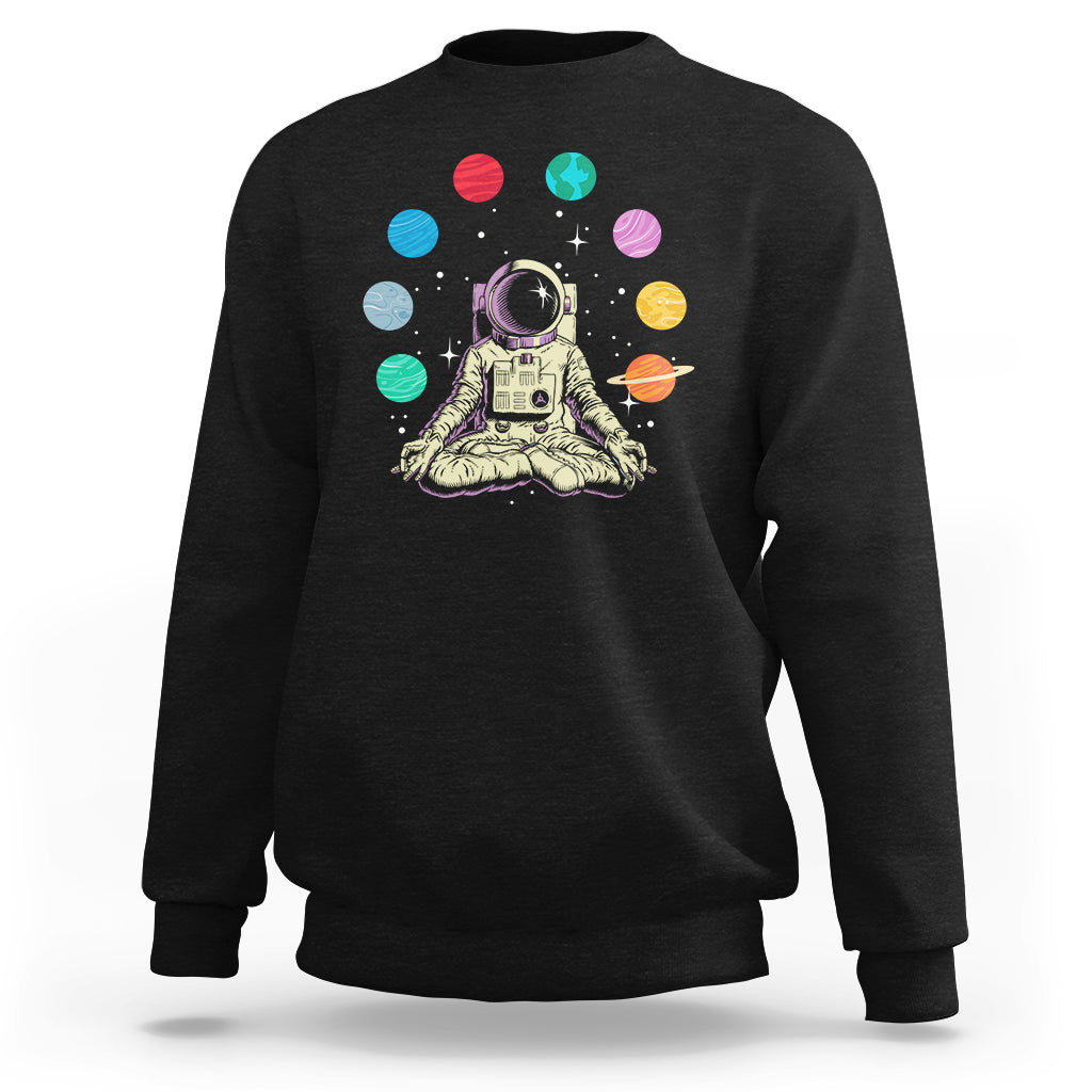 Black sweatshirt with astronaut meditating graphic and colorful solar system planets print