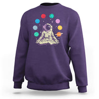 Purple sweatshirt with astronaut meditating graphic and colorful solar system planets print