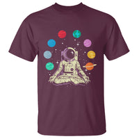 Maroon t-shirt with astronaut meditating graphic and colorful planets artwork