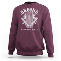 Maroon crewneck sweatshirt with white Defend graphic and Nakatomi Plaza text