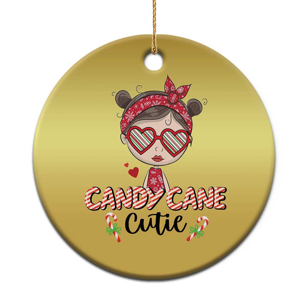 Gold round Christmas ornament with a cute girl illustration wearing red bow and heart glasses.