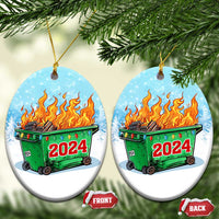 Pair of oval blue ornaments with green dumpster fire and red 2024 on snowy background.