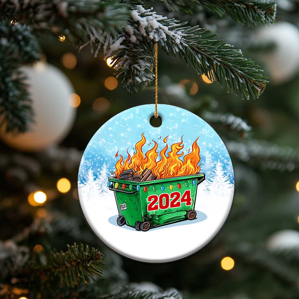 Round blue Christmas ornament on gold string, green dumpster fire with red 2024.