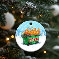Round blue Christmas ornament on gold string, green dumpster fire with red 2024.
