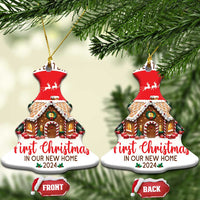 Two bell-shaped Christmas ornaments with hanging loops, red house scene, “First Christmas 2024”.
