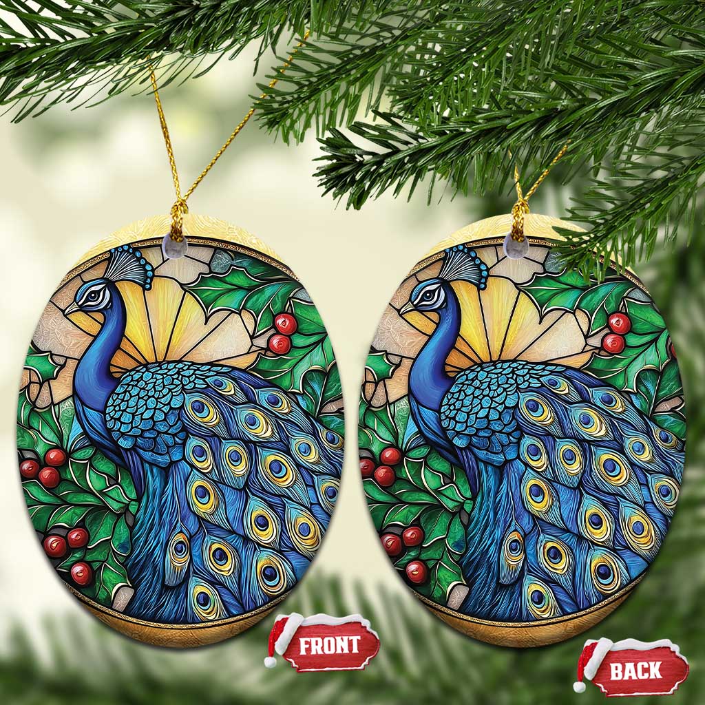 Two gold oval peacock bird ornaments with blue feathers, green leaves, and red berries