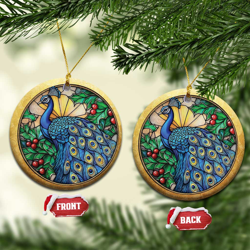 Two gold round peacock bird ornaments with blue feathers, green leaves, and red berries