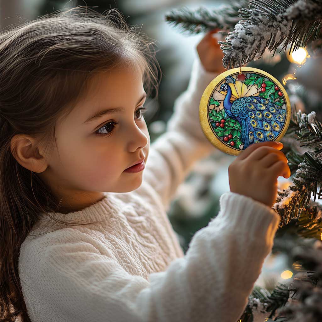 Gold round peacock bird ornament held by a child near a Christmas tree