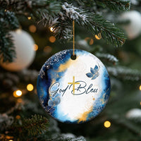 Blue and white round hanging ornament with gold cross and “God Bless” lettering