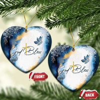 Blue and white heart-shaped Christmas ornament with gold cross and God Bless text
