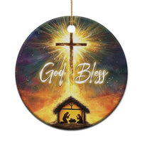 Round Christian nativity ornament with glowing cross, “God Bless” text, and manger scene