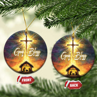 Set of two round nativity ornaments with glowing cross, “God Bless,” and manger scene