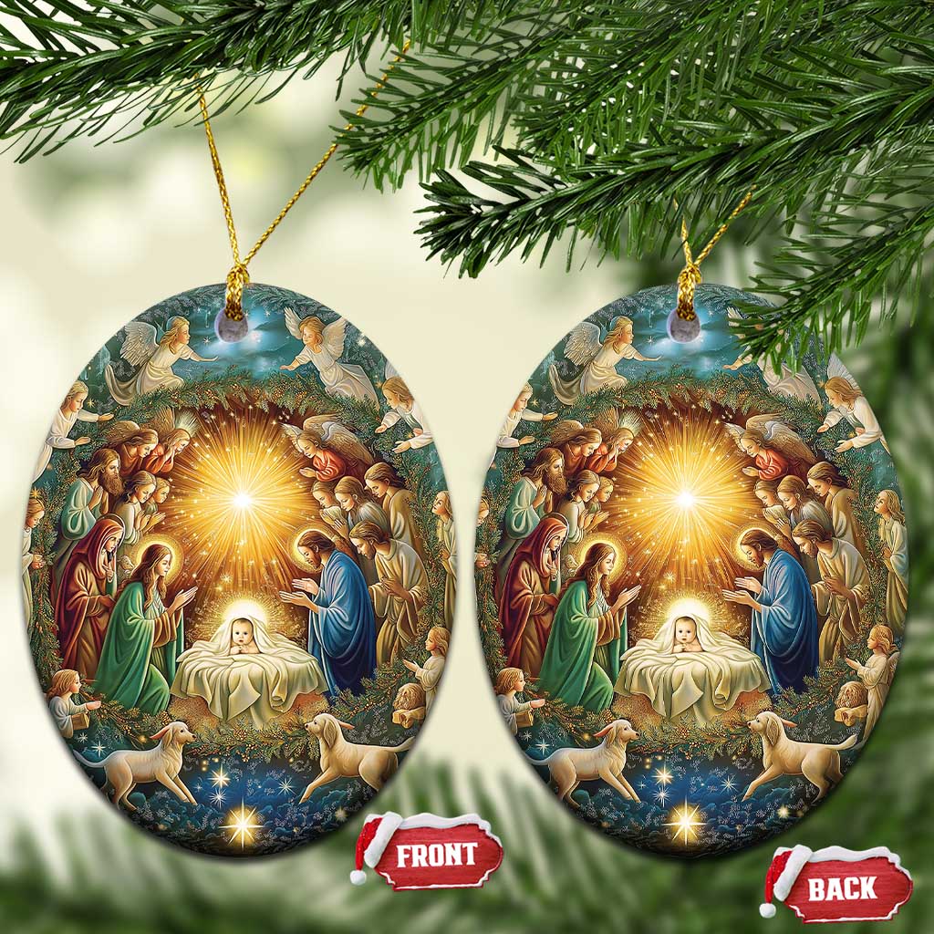 Pair of oval nativity ornaments with gold hanging cords and illuminated manger scene