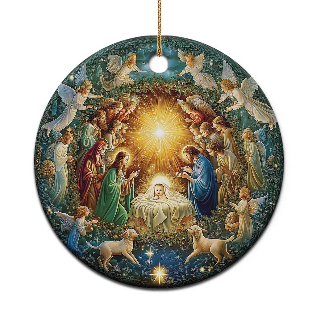 Round nativity Christmas ornament with gold hanging cord and glowing manger scene